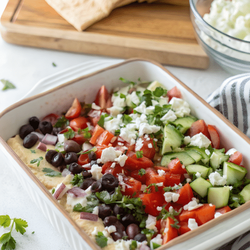 Greek layer dip with hummus vegetables and feta