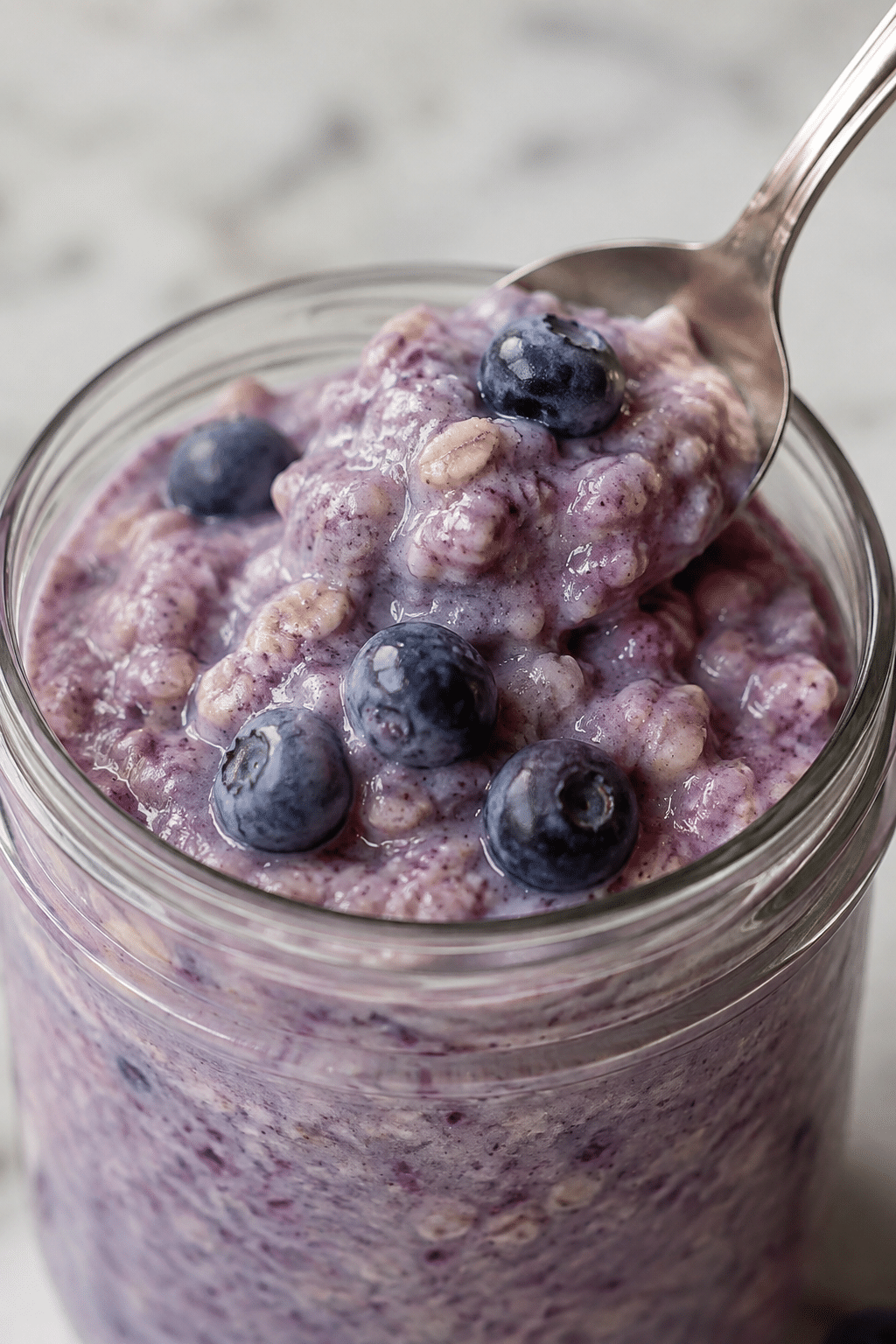 blueberry overnight oats stirred in a jar