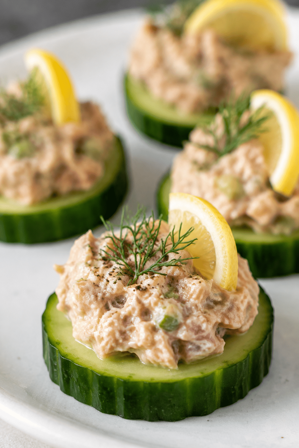 finished cucumber tuna bites garnished with dill and lemon