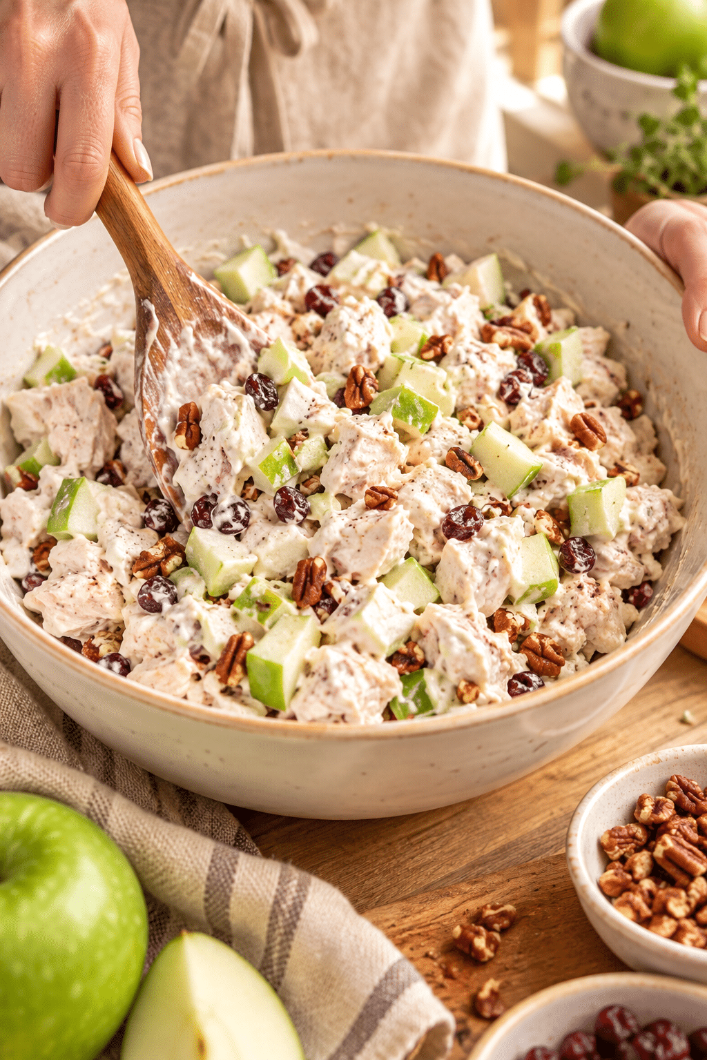 Chicken salad being gently mixed in a bowl